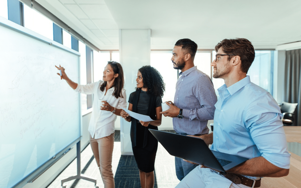 A team of coworkers meeting and planning at white board